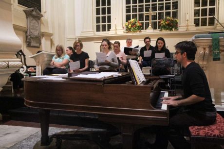 Choir group rehearsing with piano