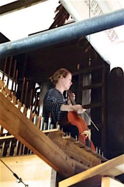 A gamba player tests acoustics in the organ case.